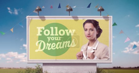 Photo for Confident vintage style businesswoman on billboard advertisement and motivational quote: follow your dreams - Royalty Free Image