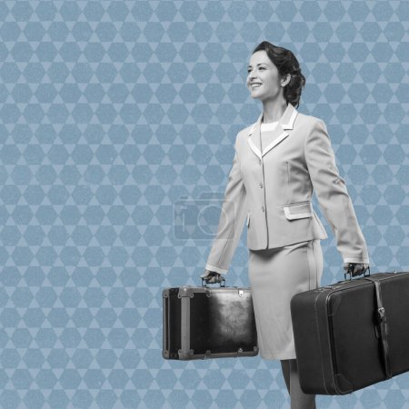 Photo for Smiling vintage woman holding suitcases ready to leave for vacations - Royalty Free Image