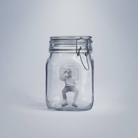 Téléchargez les photos : Homme d'affaires en transpiration stressé piégé dans un bocal en verre, concept d'isolement et de problèmes - en image libre de droit