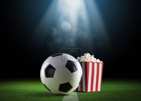 Téléchargez les photos : Balle de football et pop-corn sur le terrain : regarder des matchs de football en direct - en image libre de droit