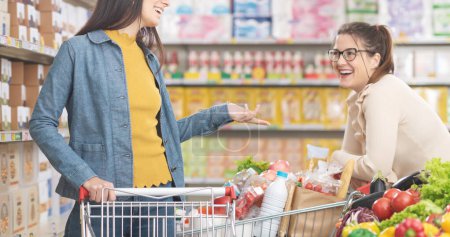 Foto de Feliz alegre reunión de mujeres en el supermercado, que están hablando juntos, el estilo de vida y el concepto de compras de comestibles - Imagen libre de derechos