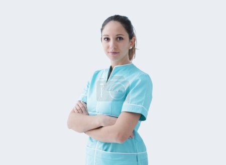 Photo for Young professional nurse posing with arms crossed and smiling at camera - Royalty Free Image