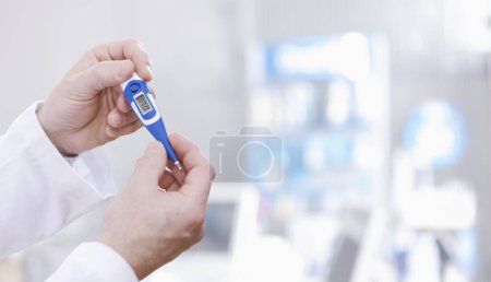 Téléchargez les photos : Médecin tenant un thermomètre numérique et mesurant la température corporelle d'un patient - en image libre de droit