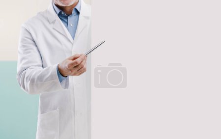 Téléchargez les photos : Docteur montrant un signe blanc vierge et pointant avec un stylo, il donne des conseils médicaux - en image libre de droit
