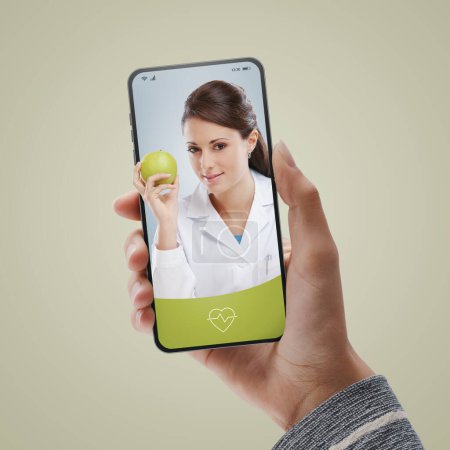 Foto de Vídeo del paciente llamando a un nutricionista en línea en el teléfono inteligente: consulta de vídeo médico en línea a petición - Imagen libre de derechos
