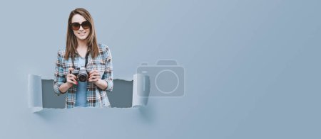 Photo for Smiling female photographer and tourist, she is posing and holding a digital camera - Royalty Free Image