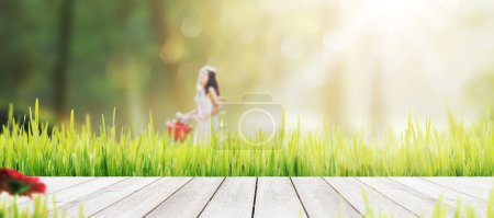 Téléchargez les photos : Passerelle en bois dans l'herbe et la femme marchant en arrière-plan - en image libre de droit