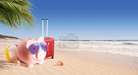Glückliches Sparschwein mit Gepäck und Sonnenbrille am Strand, preiswertes Konzept für den Sommerurlaub