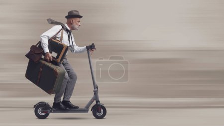 Foto de Viajero de estilo vintage que lleva equipaje y monta un scooter eléctrico rápido, espacio en blanco para copiar - Imagen libre de derechos