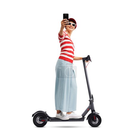 Foto de Mujer feliz montando un e-scooter y charlando con su teléfono inteligente, aislado sobre fondo blanco - Imagen libre de derechos