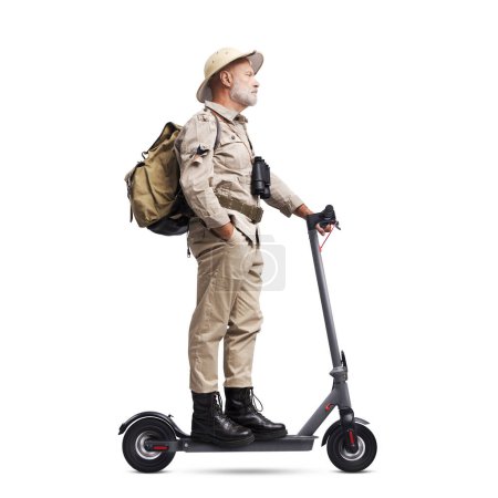 Téléchargez les photos : Explorateur de style vintage confiant chevauchant un scooter électrique, isolé sur fond blanc - en image libre de droit