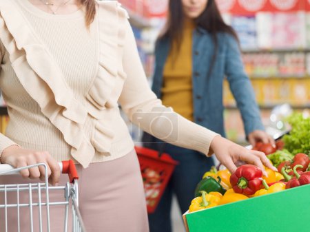 Téléchargez les photos : Clients qui achètent des légumes dans la section des produits de l'épicerie, des aliments frais et du concept d'épicerie - en image libre de droit