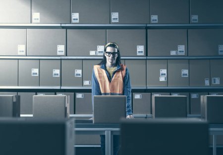 Photo for Young female worker checking packages and orders in the warehouse - Royalty Free Image