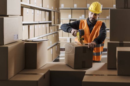 Trabajador de almacén sellando una caja de cartón con cinta adhesiva, logística y concepto de envío