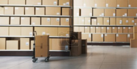 Photo for Defocused Warehouse interior with many delivery boxes and trolley: delivery and logistics concept - Royalty Free Image