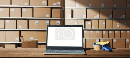 Photo for Laptop with blank screen on a desk at the warehouse, delivery and logistics service concept - Royalty Free Image