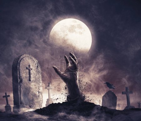 Téléchargez les photos : Zombie se levant de la tombe : main effrayante sortant du sol et vieilles pierres tombales - en image libre de droit