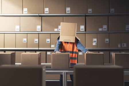 Frustrierte depressive Lagerarbeiterin mit Schachtel auf dem Kopf: Entfremdung im Arbeitsplatzkonzept