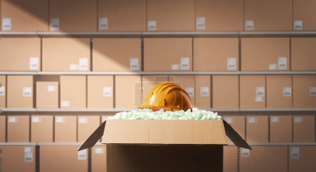Photo for Safety and health at work: protective safety helmet in a delivery box filled with packing chips - Royalty Free Image