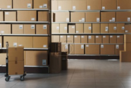 Foto de Interior del almacén desenfocado con muchas cajas de entrega y carro: concepto de entrega y logística - Imagen libre de derechos