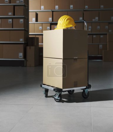 Foto de Almacén de distribución interior con cajas de entrega y carro: concepto de logística, entrega y almacenamiento - Imagen libre de derechos
