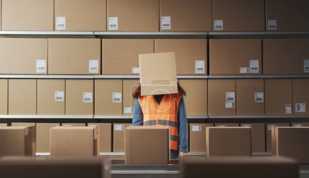 Frustrierte depressive Lagerarbeiterin mit Schachtel auf dem Kopf: Entfremdung im Arbeitsplatzkonzept