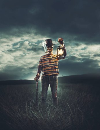 Foto de Mal personaje aterrador con la cabeza del cráneo de pie en los campos y sosteniendo una linterna - Imagen libre de derechos