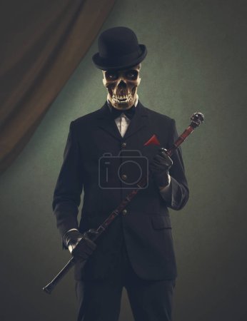Téléchargez les photos : Personnage d'horreur effrayant avec tête de crâne portant un costume élégant et posant - en image libre de droit