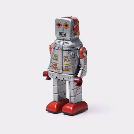 Divertido robot de juguete vintage de hojalata sobre fondo blanco, juguetes enrollables y concepto de coleccionables