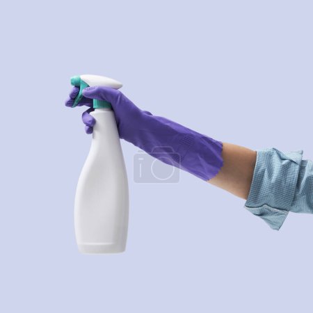 Foto de Mano femenina que lleva un guante de limpieza y sostiene una botella de detergente en aerosol, concepto de higiene y limpieza de la casa - Imagen libre de derechos