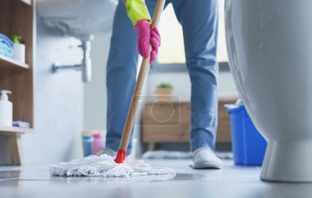Woman mopping the floor and cleaning up her home