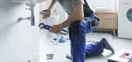 Plombier remplaçant les tuyaux d'évier à la maison, concept de service professionnel