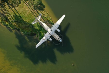 Vintage airplane on river bank, aerial view 