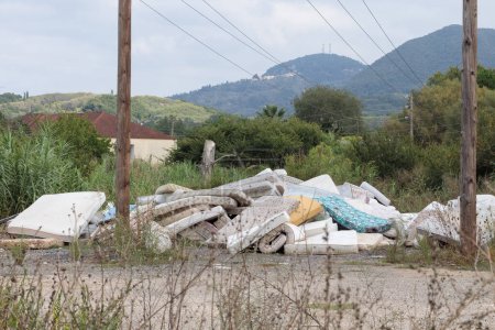 Large group of used dirty sleeping mattresses. Abandoned in wild landfill