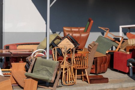 Téléchargez les photos : Vieux meubles endommagés à la décharge près de la maison en brique. Un gros problème. - en image libre de droit