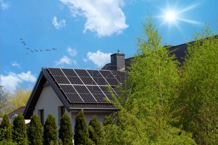 Foto de Techo a dos aguas con paneles solares. Moderna, atractiva casa y energía solar. Rayos de sol - Imagen libre de derechos