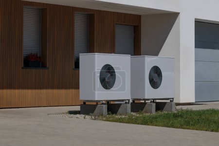 Moderne Hausfassade mit installierten Luftquellen-Wärmepumpen. Konzept der erneuerbaren Energien