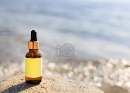 Téléchargez les photos : Flacon compte-gouttes avec fond de plage flou. Concept cosmétique ou médecine naturelle. - en image libre de droit