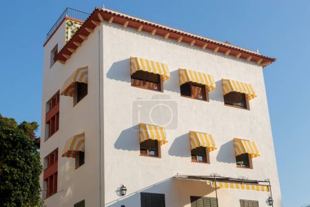 Foto de Tossa de Mar, España - 13 de agosto de 2023 Edificio con elegantes toldos amarillos - Imagen libre de derechos