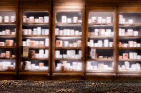 Foto de Contador de madera oscura con estantes de farmacia borrosa ideal para presentaciones de productos o maquetas. - Imagen libre de derechos