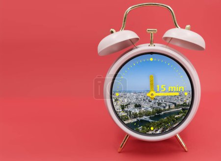 Téléchargez les photos : 15-minute city concept inside a ringing twin bell vintage classic alarm clock Isolated on red. A 15-minute city is a residential urban concept in which most daily necessities can be accomplished by - en image libre de droit