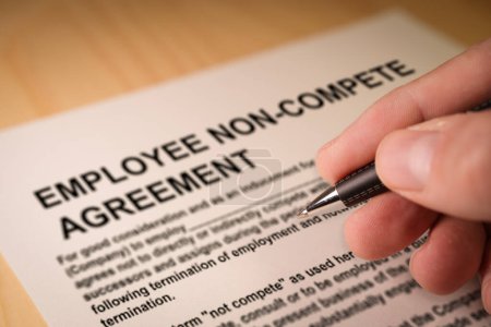 Photo for Man signing an employee Non-compete agreement. Selective focus - Royalty Free Image
