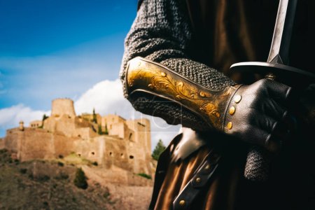 Knight holding a sword and the medieval castle of Cardona in the background. Selective Focus