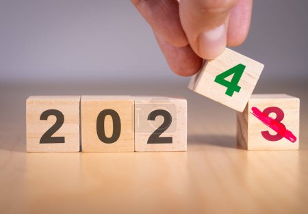 Hand, die die Zahl 3 auf 4 ändert, um den Jahreswechsel von 2023 auf 2024 zu symbolisieren. Ab Neujahr 2024. Anfang und Anfang des Jahres. Vorbereitung auf das neue Jahr, Leben, Geschäft, Plan, Ziele