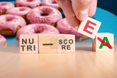 Photo for Hand changing the expression nutri-score A to nutri-score E. The Nutri-Score, also known as the 5-Colour Nutrition label or 5-CNL, is a five-colour nutrition label and nutritional rating system. - Royalty Free Image