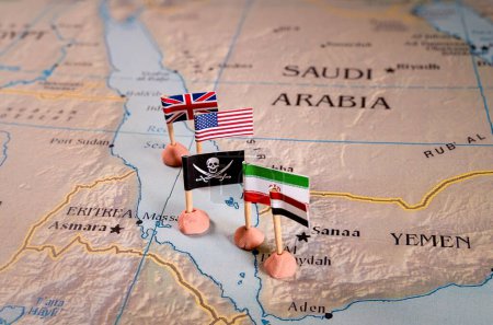 Téléchargez les photos : Drapeaux des États-Unis et de l'Iran et leurs alliés respectifs entourant un insigne de pirate sur une carte de la région de la mer Rouge. Il représente symboliquement la dynamique géopolitique complexe et - en image libre de droit