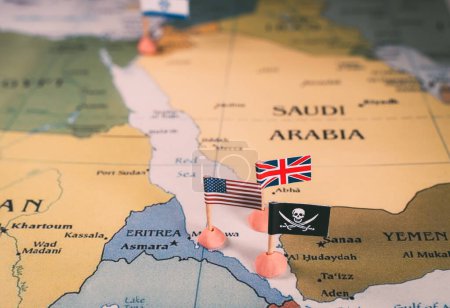 Foto de Banderas de los Estados Unidos y el Reino Unido que rodean una insignia pirata en un mapa de la región del Mar Rojo. vídeo vertical. Representa simbólicamente la intrincada dinámica geopolítica y - Imagen libre de derechos