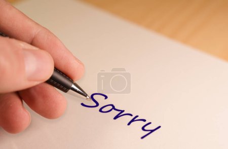 Großaufnahme einer Hand, die einen Stift hält und das Wort Sorry auf ein Blatt Papier schreibt. Ideal, um Entschuldigungen, Reue und Wiedergutmachung auszudrücken. Perfekt für den Einsatz in Entschuldigungskarten, Nachrichten und