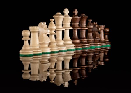 Foto de Línea diagonal de piezas de ajedrez de madera aisladas en el fondo con reflexión transparente en el suelo - Imagen libre de derechos