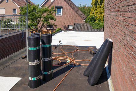Foto de Urk, Países Bajos - 23 de junio de 2022: Techo plano con rollos de nuevo fieltro blanco para techos o betún - Imagen libre de derechos
